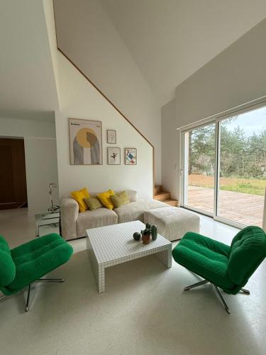 a living room with a couch and two green chairs at Villa la Hune- Proche Golfs & Plage in Neufchâtel-Hardelot
