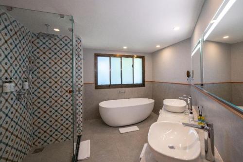 a bathroom with a tub and a toilet and a sink at Sea Cliff Resort & Spa in Zanzibar City