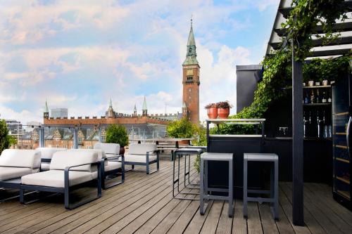 a balcony with chairs and a clock tower on a building at Hotel Danmark in Copenhagen
