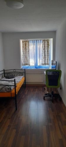 a room with two beds and a window and a chair at Ela Gar 2 WG Zimmer in Garsten