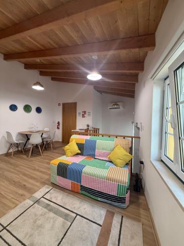 a living room with a bed and a table at Casa das Flores in Sardoal