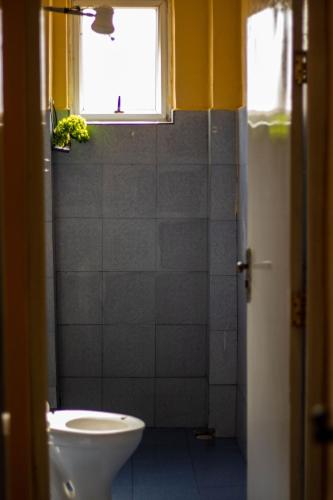 a bathroom with a toilet and a window at Hecahomes in Kericho
