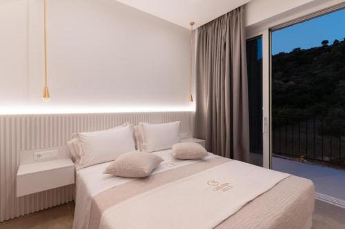 a bedroom with a white bed with a large window at Apartment Athina with direct pool access - GH8 in Gialova