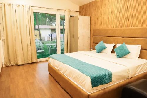 a bedroom with a bed and a large window at Agonda Junction in Agonda