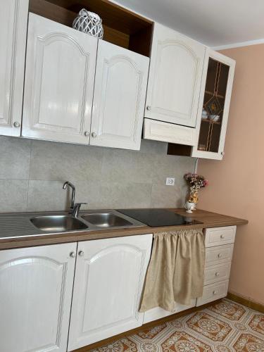 a kitchen with white cabinets and a sink at La Casa del Sole in Corleone