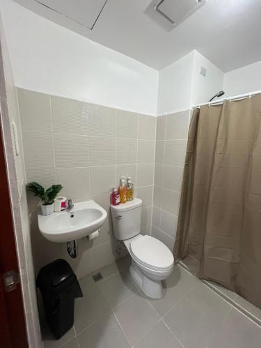 a bathroom with a toilet and a sink and a shower at Hailey's Place Unit 3 in Bacolod