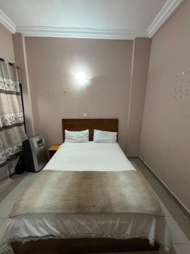 a bedroom with a large bed in a room at Jassehs Apartments in Brusubi