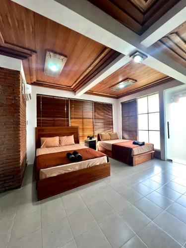 two beds in a room with wooden ceilings at PaddyView Hostel in Banyuwangi
