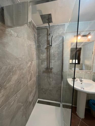 a bathroom with a shower and a sink at Hostal Hueso in Trujillo
