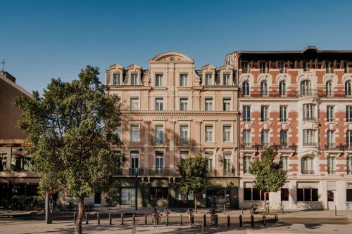 a large brick building with trees in front of it at Matabi Hotel Toulouse Gare by HappyCulture in Toulouse