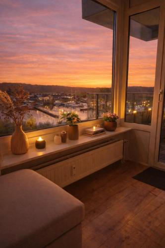 a room with a window with candles and a view at Strandhafer-Balkon mit Meerblick- 2 Min zum Strand in Schausende