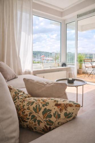 a living room with a couch and a large window at Strandhafer-Balkon mit Meerblick- 2 Min zum Strand in Schausende