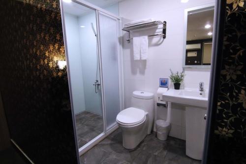 La salle de bains est pourvue de toilettes, d'une douche et d'un lavabo. dans l'établissement Hotel 6 - Wannien, à Taipei