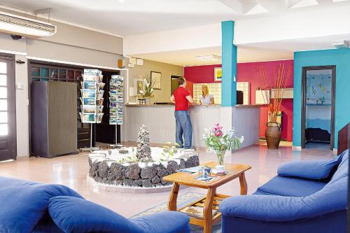 a man standing at the counter of a store at BLUESEA Puerto Caleta in Caleta De Fuste