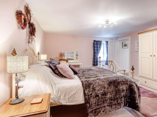 a bedroom with a bed and a desk with a lamp at 4 Bed in Pitlochry oc-ca274 in Foss