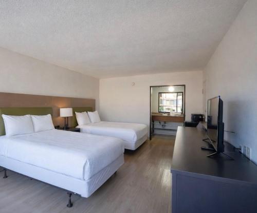 ein Hotelzimmer mit zwei Betten und einem Flachbildfernseher in der Unterkunft 1st Place Hotel Decatur I-20 East Atlanta in Decatur