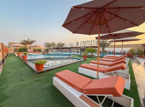 a pool with chairs and umbrellas at a resort at GGIVV VACATION HOMES RENTAL 1400 FT 1 BEDROOM LUXURY SERVICE Apartment in Dubai