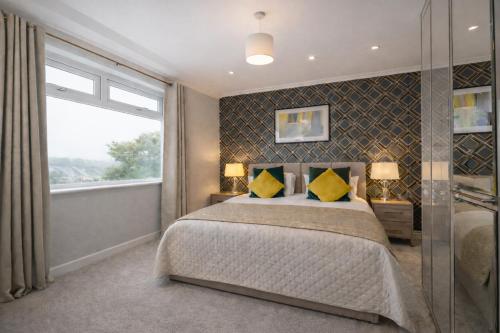 a bedroom with a large bed with yellow pillows at Taylor House - Durham in Bearpark
