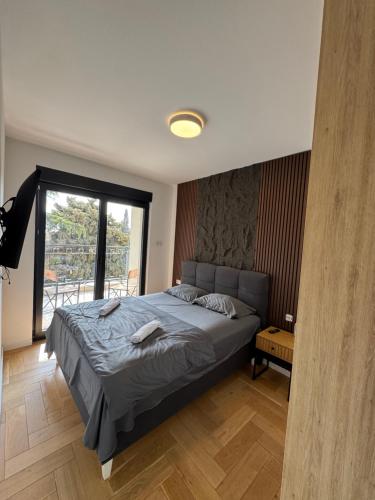 a bedroom with a bed and a large window at ToP-HILL in Trebinje