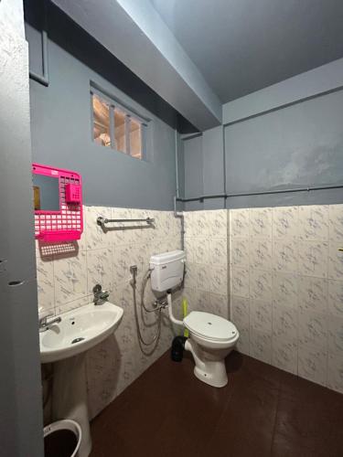 a bathroom with a toilet and a sink at Verde Guest House in Shillong