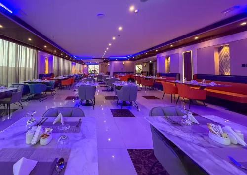 a restaurant with tables and chairs and purple lighting at GGIVV VACATION HOMES RENTAL 1400 FT 1 BEDROOM LUXURY SERVICE Apartment in Dubai