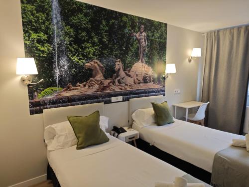 a hotel room with two beds and a painting on the wall at Hostal Fronton in Alcobendas
