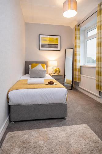 a bedroom with a king sized bed and a mirror at Taylor House - Durham in Bearpark