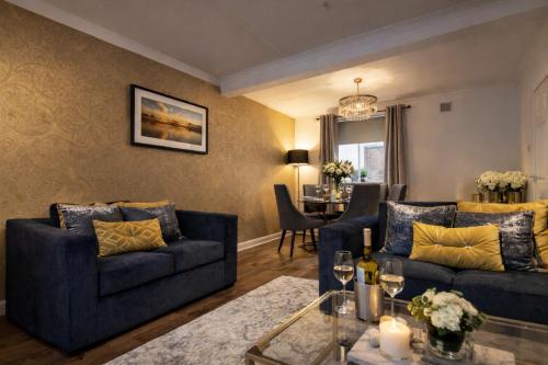 a living room with two blue couches and a table at Taylor House - Durham in Bearpark