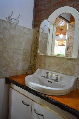 a bathroom with a sink and a mirror at Cabañas "La Quimera" in El Durazno
