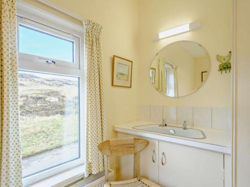 a bathroom with a sink and a mirror and a window at 4 Bed in Scourie oc-ca399 in Scourie