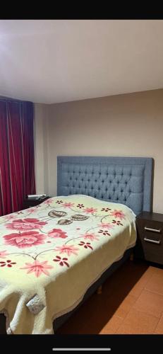 a bedroom with a bed with a floral bedspread at cris in Sierra de los Padres