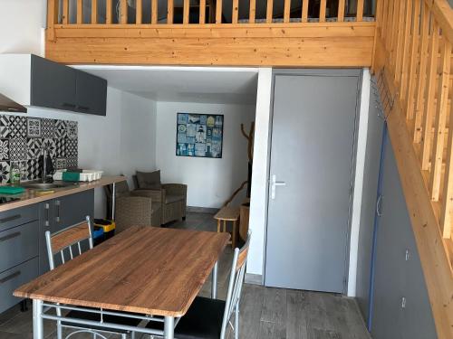 a kitchen and dining room with a wooden table at Le Cap Ferret in La Teste-de-Buch