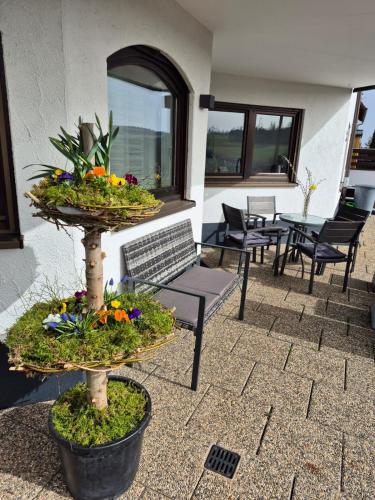 a patio with a table and chairs and a plant at Ferienwohnung Familie Aestel in Altensteig