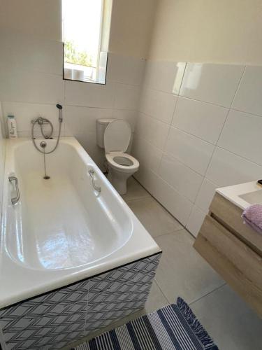 a white bathroom with a tub and a toilet at Williston Bly of Gly in Williston