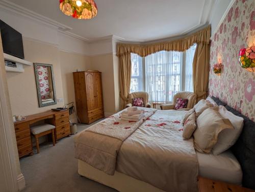 a bedroom with a large bed and a window at Del Mar in Llandudno