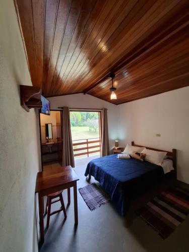 a bedroom with a bed and a wooden ceiling at Pousada Vitoria in Gonçalves