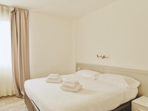 a bedroom with a white bed with towels on it at Toscana Ambassador in Poggibonsi