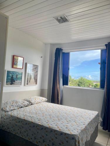 a bedroom with a bed and a large window at Flat Bela Amarração in Luis Correia