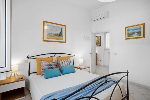 a bedroom with a bed with blue and orange pillows at Follonica Vacanze 7 in Follonica