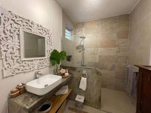 a bathroom with a sink and a shower with a mirror at Villa Evalia in Albion