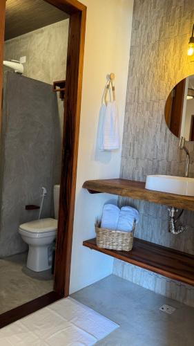 a bathroom with a sink and a toilet and a mirror at Vila Marina Icaraizinho in Icaraí