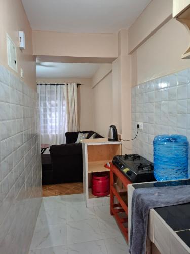 a kitchen with a stove and a living room at Baraka Stay,Kenol,Gitura,Murang'a in Gitura