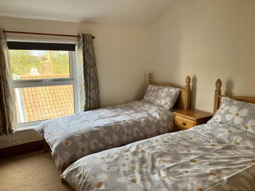 a bedroom with two beds next to a window at Fiona's House in Filey
