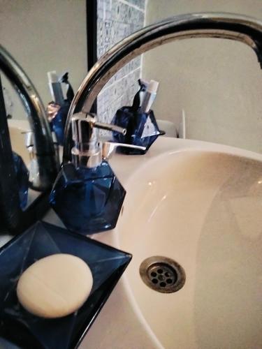 a bathroom sink with a faucet with a sponge at le Cabanon Beldi in Rabat
