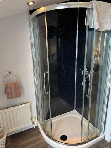 a shower with a glass door in a bathroom at The Penthouse- The Kingsley Collection in Troon