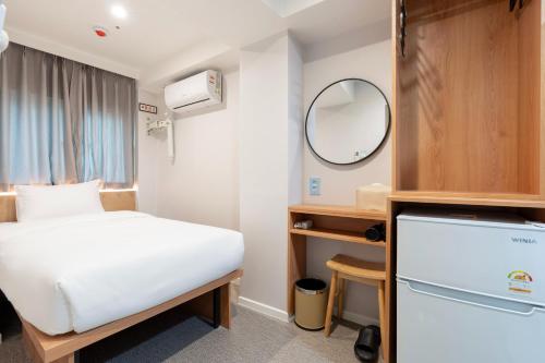 a small room with a bed and a mirror at KIMSTEL Jongno in Seoul