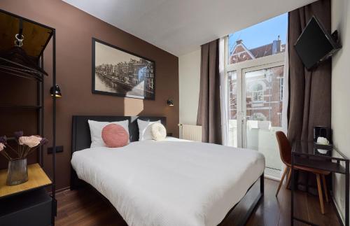 a hotel room with a large bed and a window at Quentin Museum Square Hotel in Amsterdam