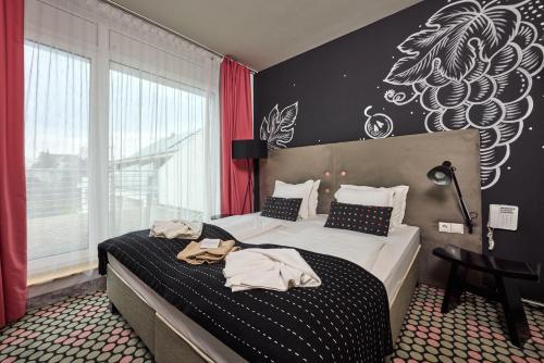 a hotel room with two beds with towels on them at Hotel Bonvino Badacsony in Badacsonytomaj
