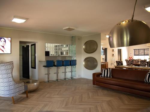 a salon with a leather couch and blue chairs at Stay in Postmasburg