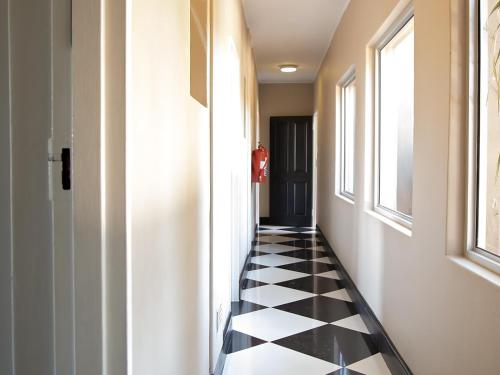 a hallway with a black and white checkered floor at Stay in Postmasburg